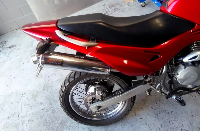 Red Honda motorcycle fitted with a polished BOSSON slip-on