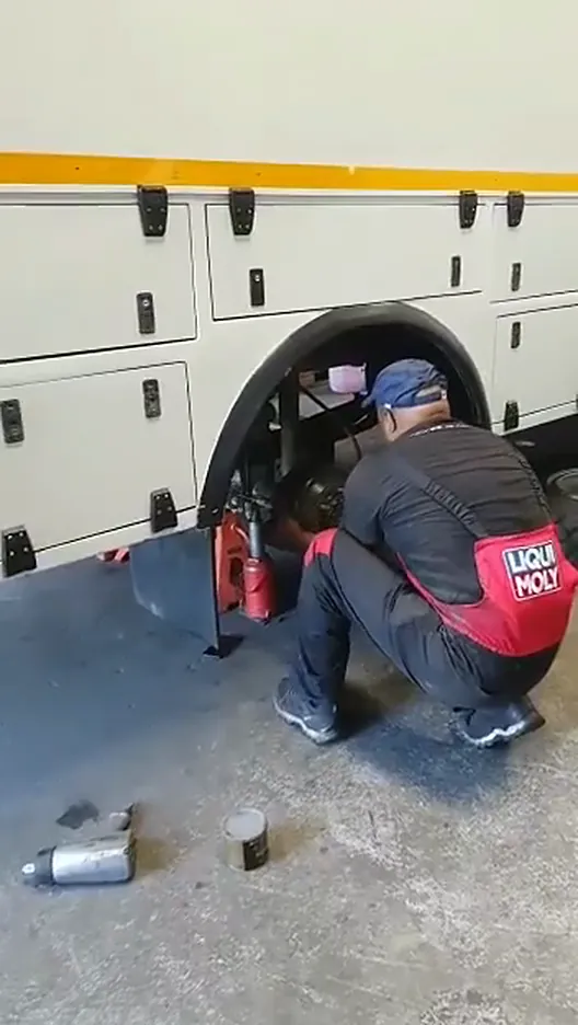 Mechanic crouched at the front wheel of the Daily 4x4